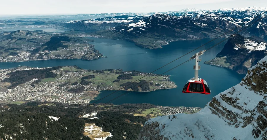A red cableway cabin above the lake and the city of Lucerne